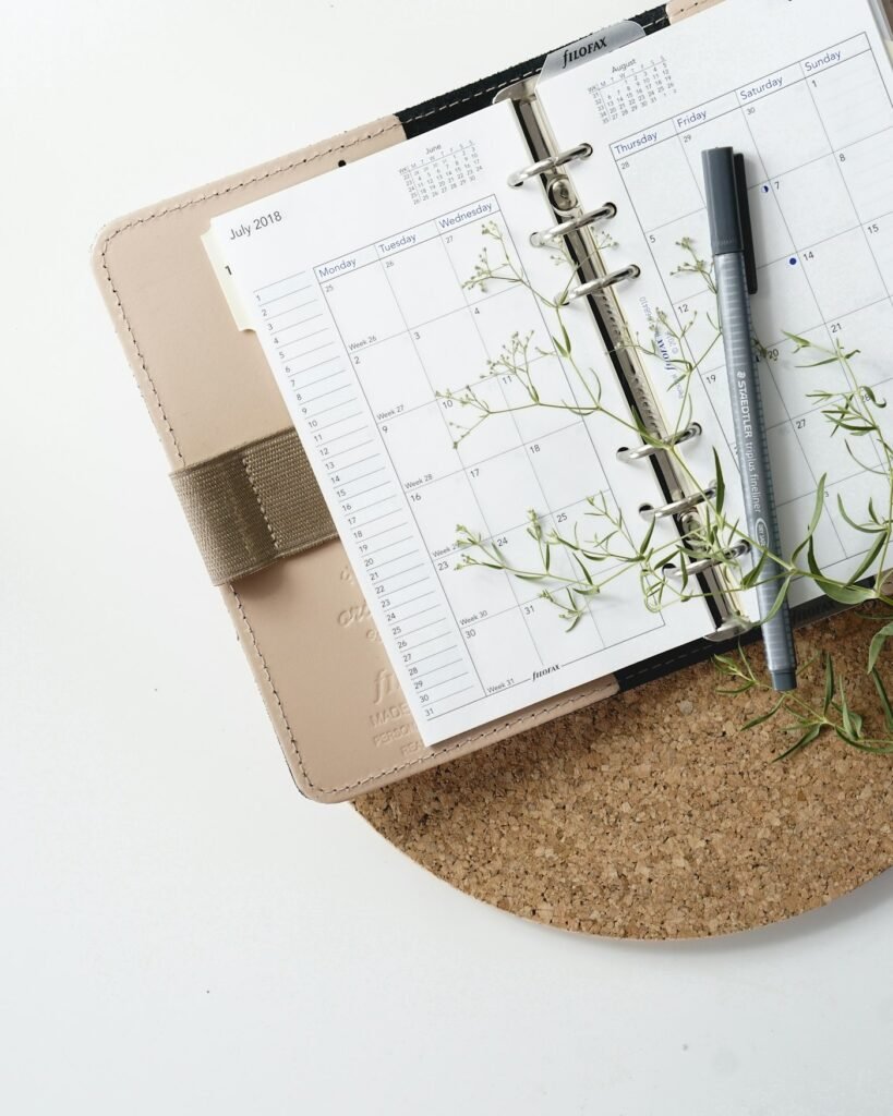 Pen resting on a calendar planner used to track monthly income and bills