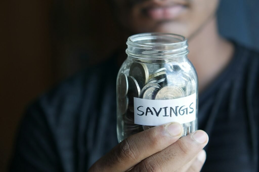 Person holding a glass jar labeled savings, representing the 20 percent savings goal