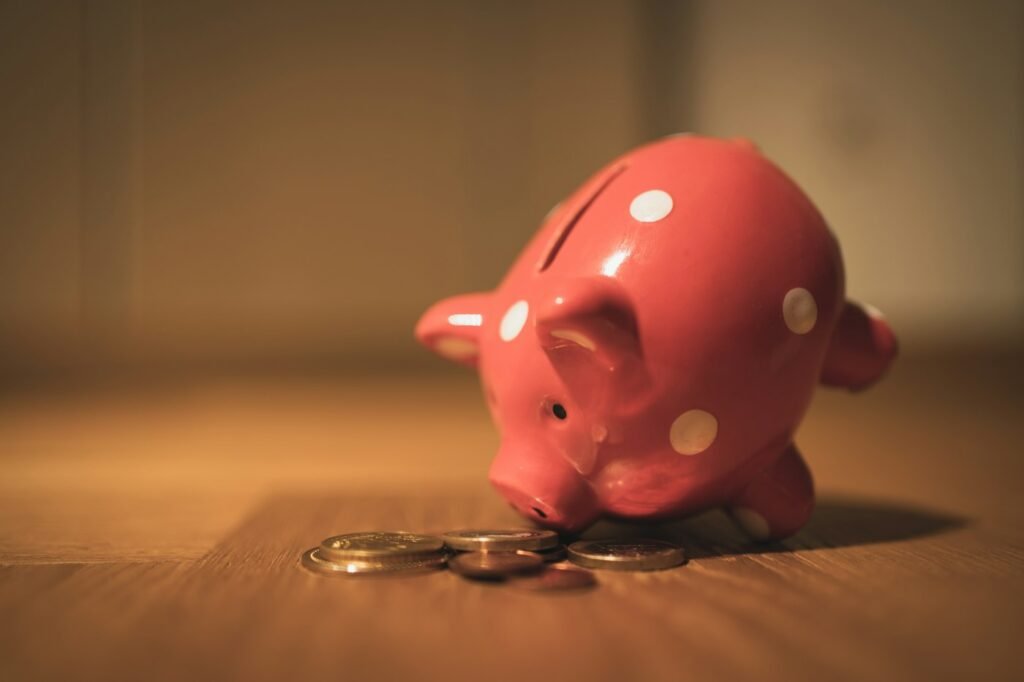 Pink piggy bank on a wooden table representing savings in a 50/30/20 budget