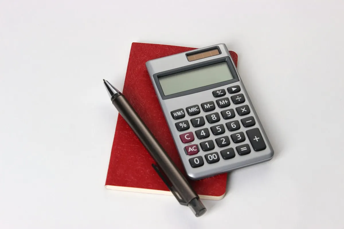 Calculator and notebook used to work out a monthly sinking fund contribution