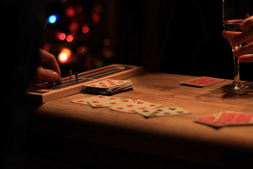 12 Best 2 Player Card Games for Couples (Easy Rules for Date Night) 3 Playing cards laid out on a wooden table for a game of cribbage for two players