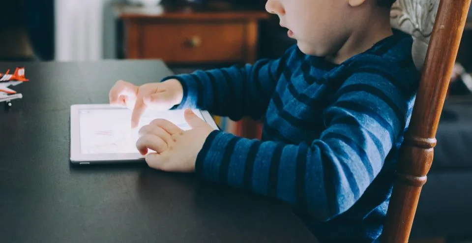 Young boy playing an educational learning app on a tablet