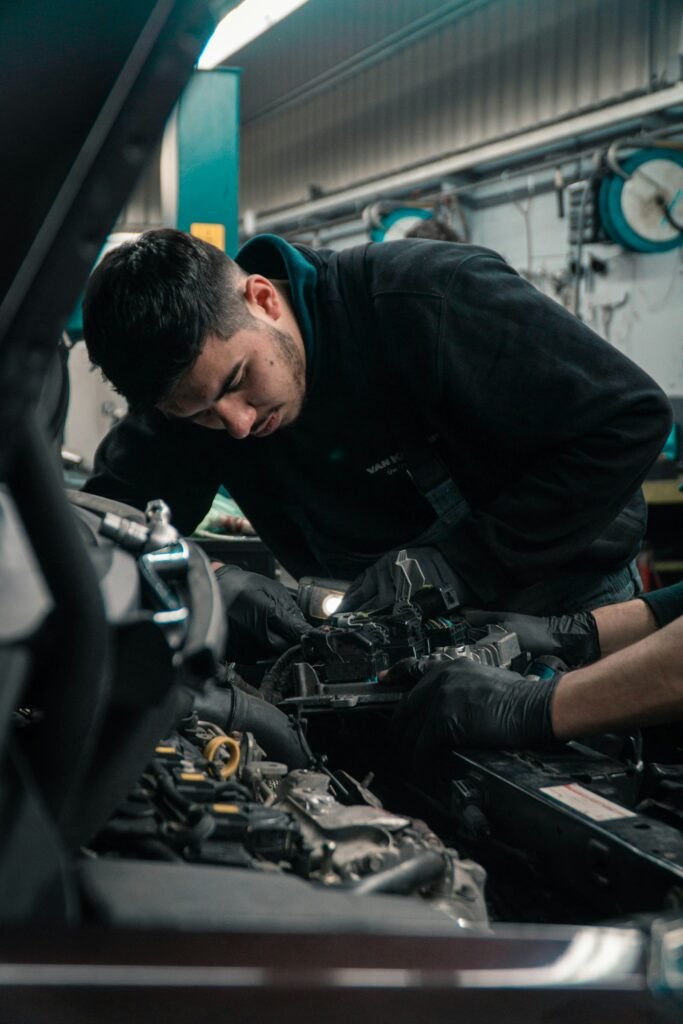 Clicking Noise When Trying to Start Car? 7 Causes and How to Fix Them 5 Mechanic inspecting a car engine to diagnose a starter problem