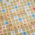 Educational games: wooden letter tiles spelling education and learning on a game board