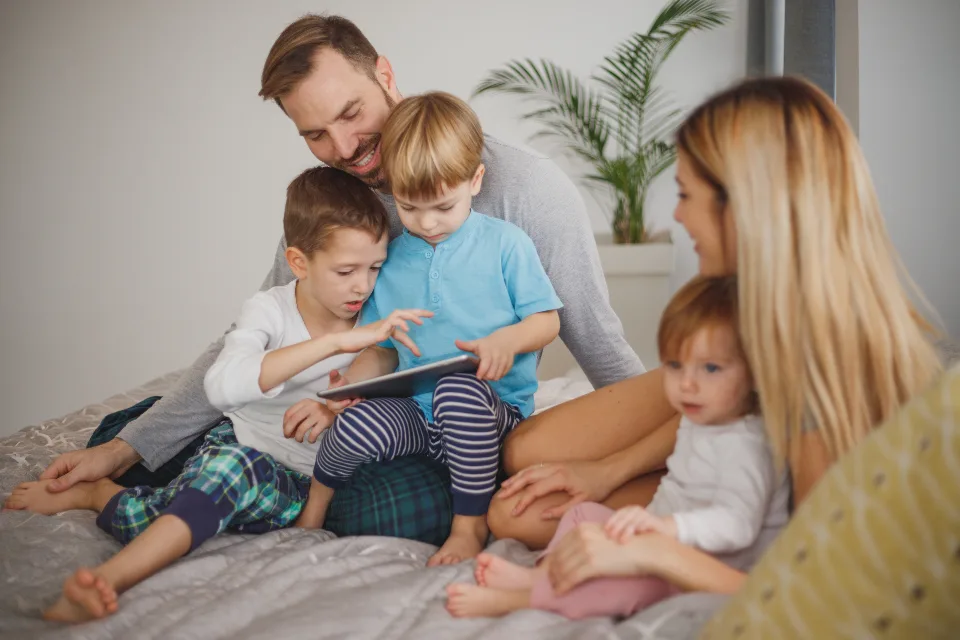 Family sitting together on the floor playing learning games with kids