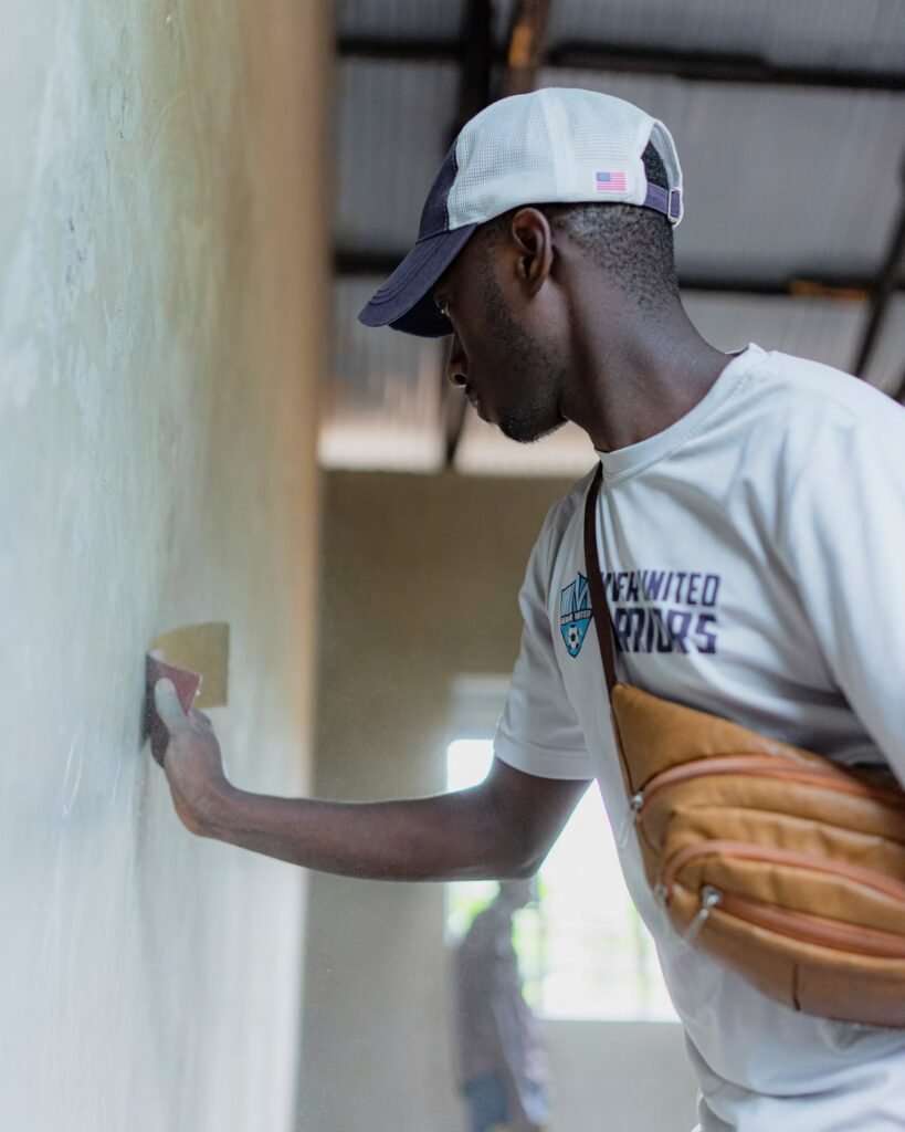 Man smoothing and feathering joint compound on a repaired wall