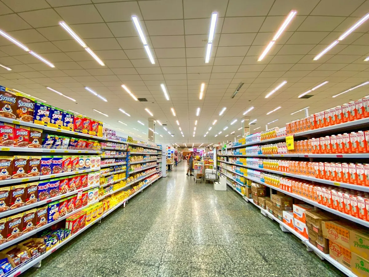 How to Save Money on Groceries: A Simple Weekly System That Works 3 Grocery store aisle where shoppers compare prices and store brands