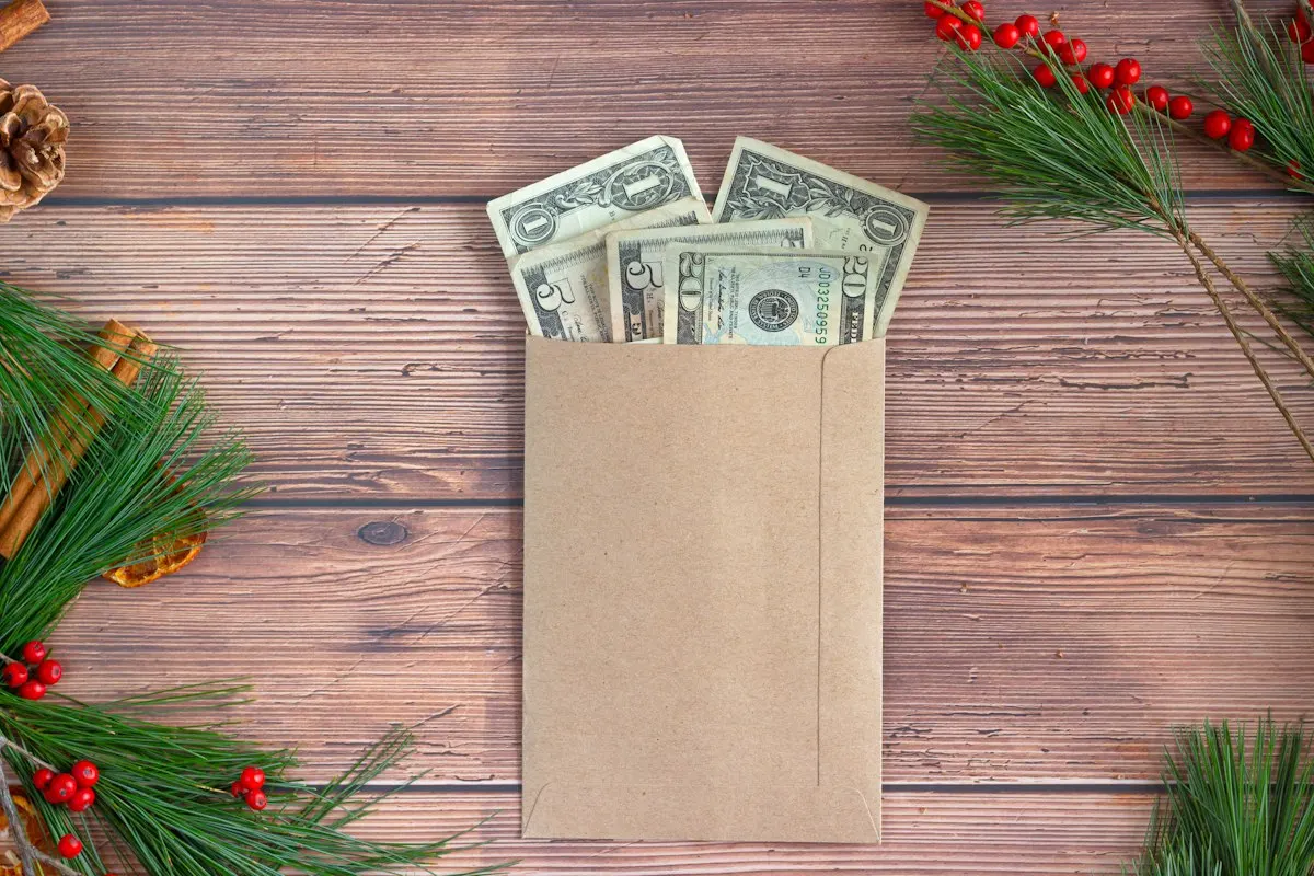 Cash envelope surrounded by holiday decorations for a gift and holiday sinking fund