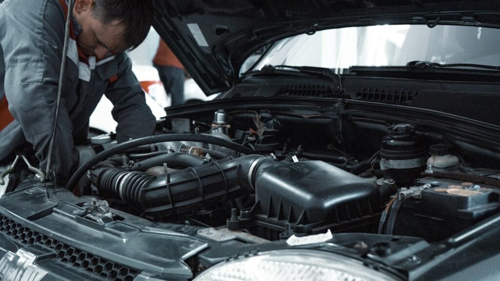 How to Change a Car Air Filter: Easy 10-Minute DIY Guide (With Photos) 5 Mechanic inspecting a car engine under the open hood during routine maintenance