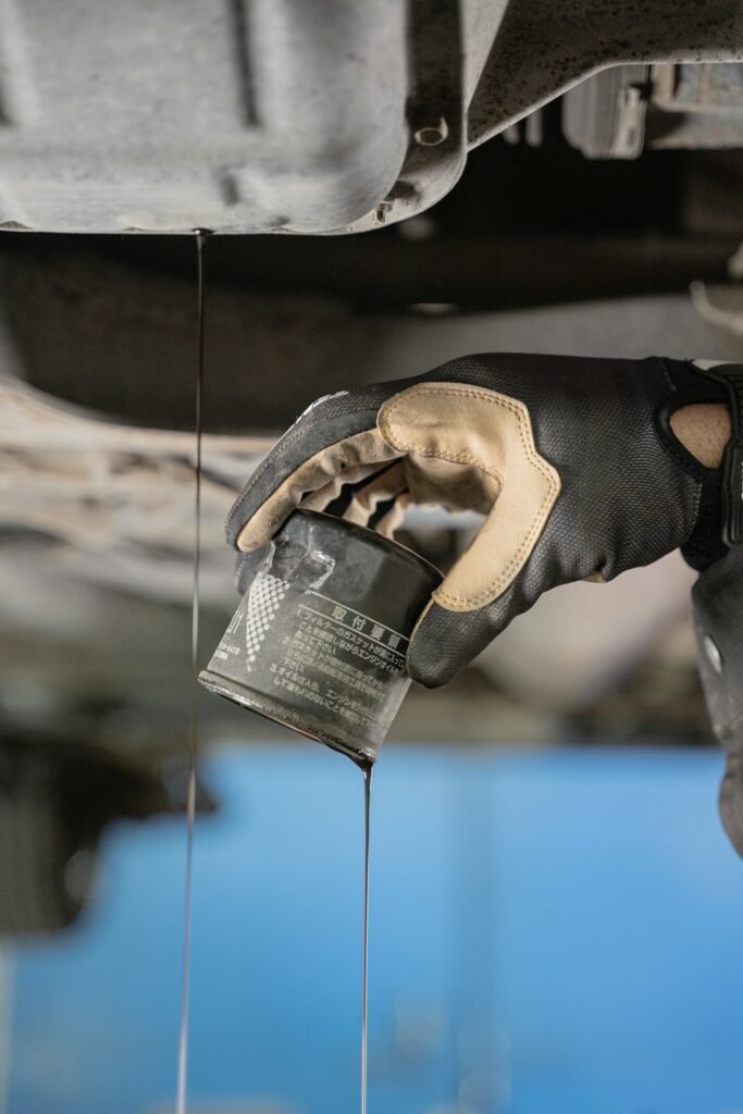 How to Check Oil Level in Your Car: A 5-Minute Beginner's Guide 4 Mechanic pouring fresh motor oil into a car engine through the filler opening
