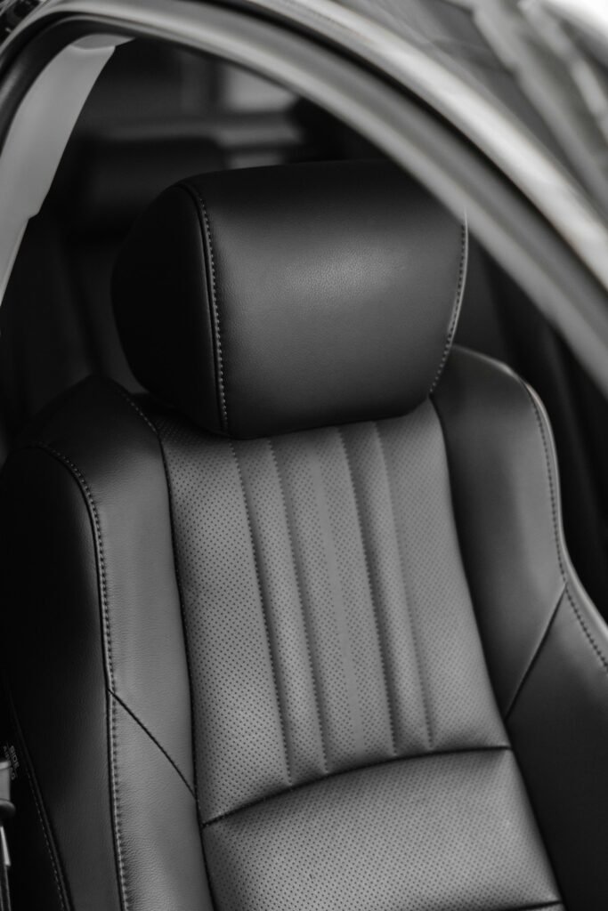 Close-up of a black leather car seat ready for cleaning and conditioning