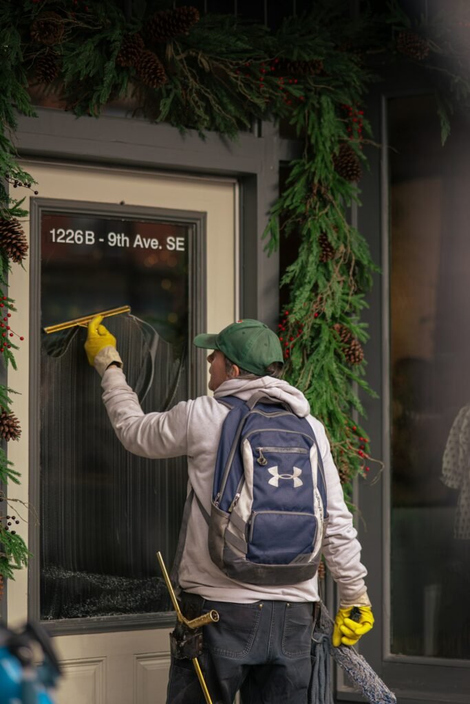 How to Clean Window Screens: 4 Easy Methods (With or Without Removing) 5 Man cleaning a window with a squeegee after washing the screens