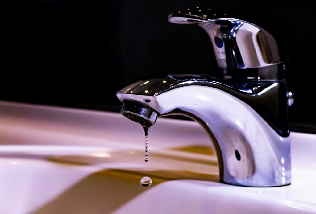 Stainless steel faucet over a white ceramic sink after a successful leak repair