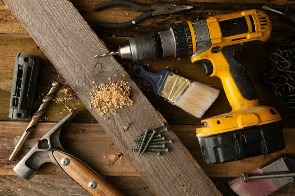 Basic DIY tools laid out on a table for repairing a squeaky wooden floor