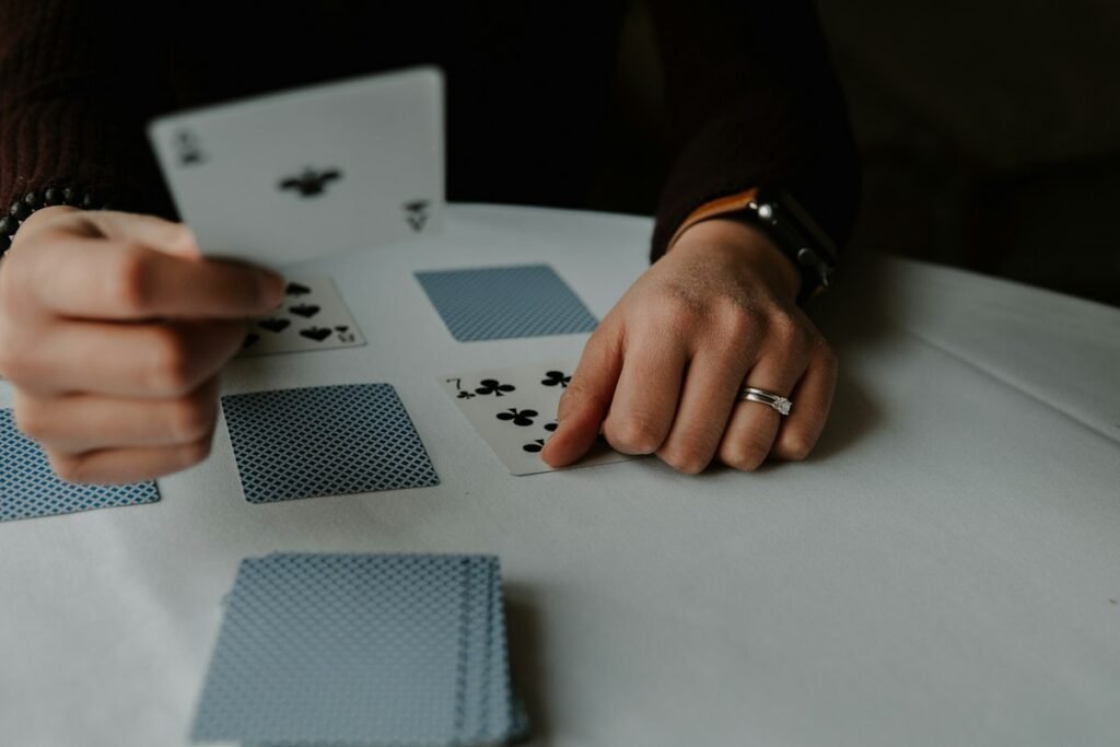Player holding a hand of playing cards on a white table