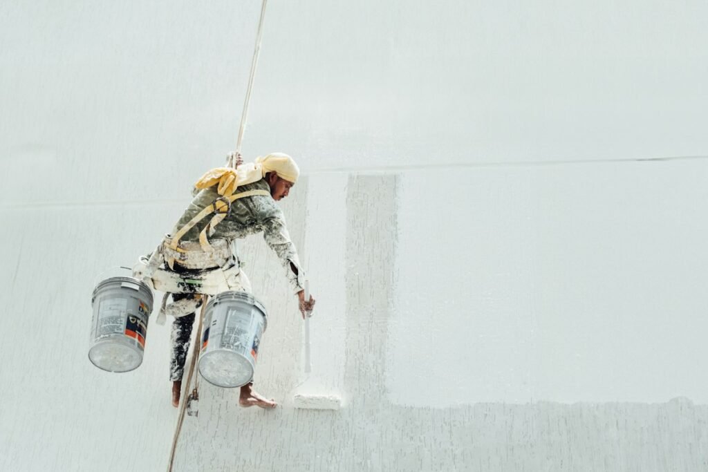 Painter applying primer to a smooth white wall