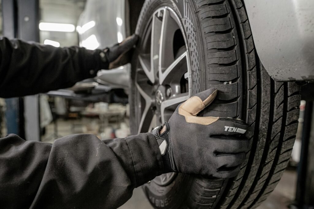 Man checking a car tire in a garage to improve fuel economy