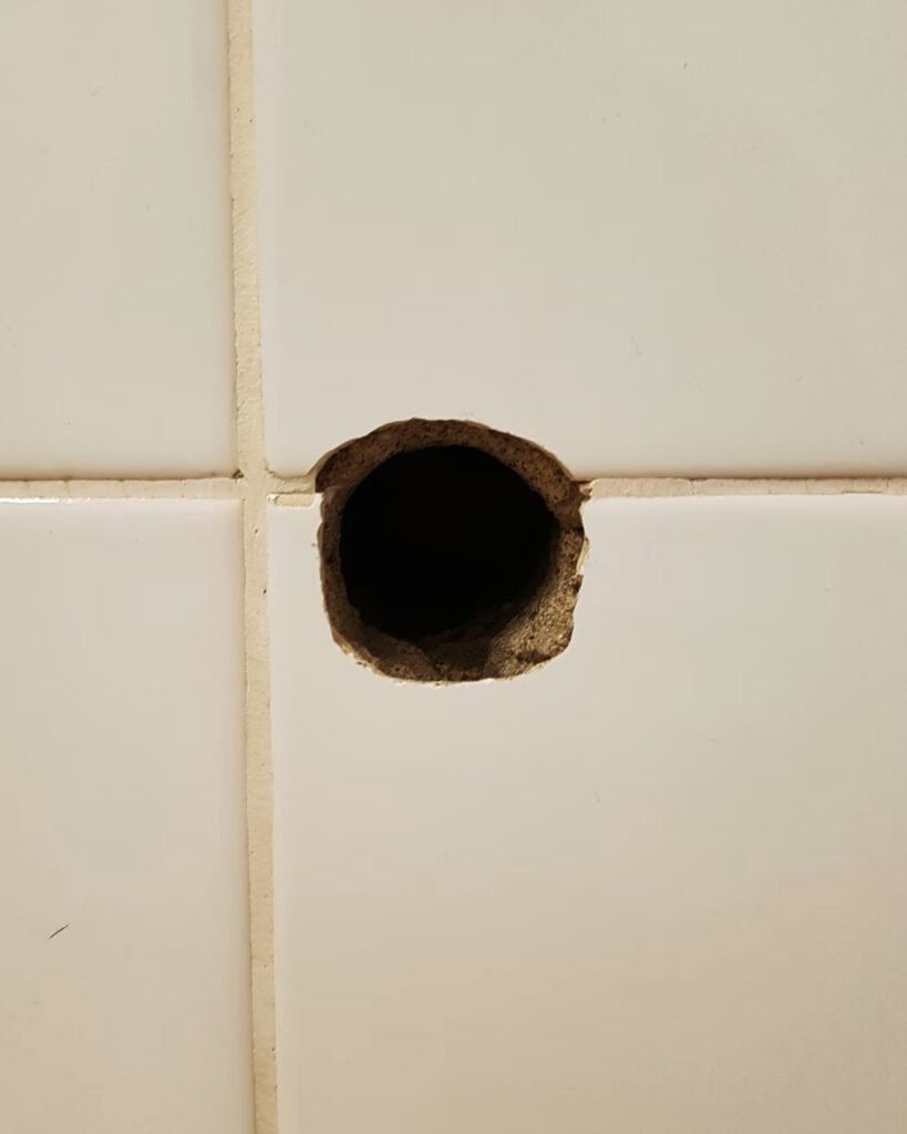 Large hole in a drywall wall before patching