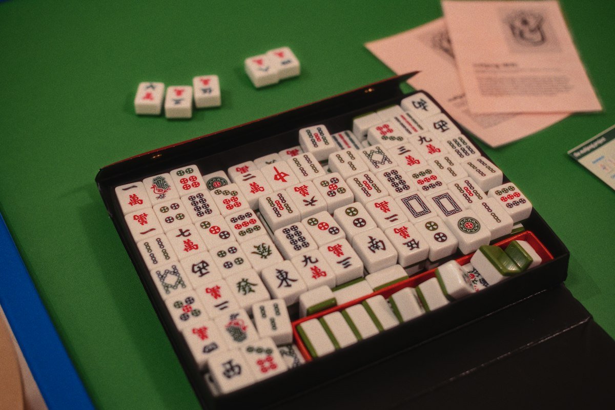 How to Play Mahjong: Rules, Tiles, and Tips for Beginners 3 Mahjong tiles arranged on a green table showing suits and honor tiles