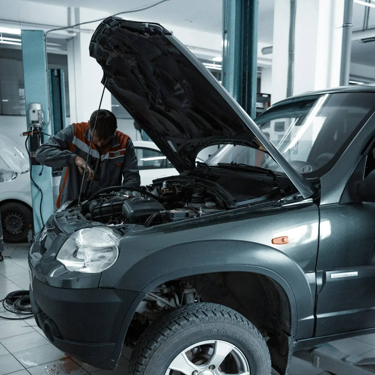 How Many Miles Is Too Many for a Used Car? A Realistic Buyer's Guide 4 Mechanic inspecting a used SUV with the hood open before purchase