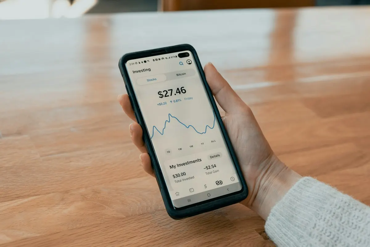 Hand holding a smartphone showing a savings account balance for sinking fund money