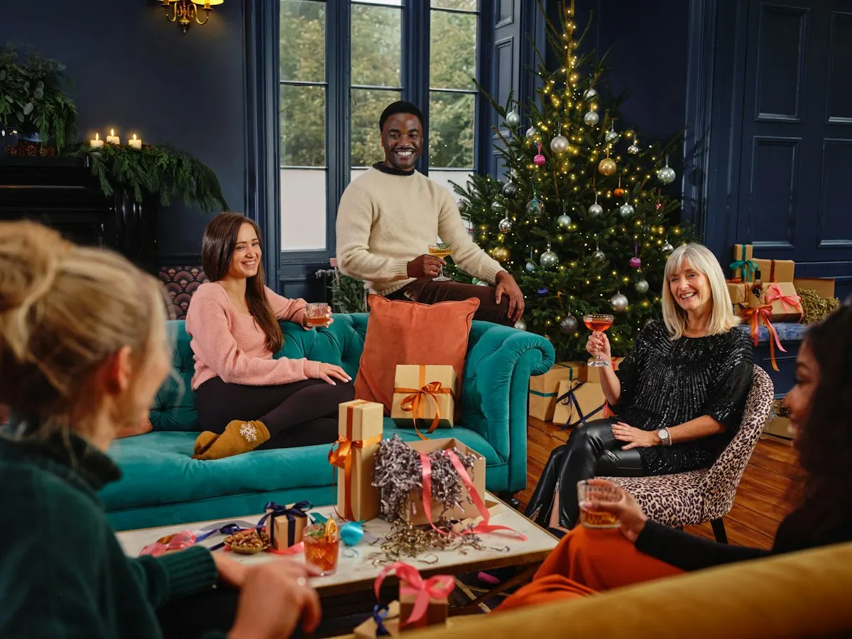 Friends gathered at a holiday party playing a white elephant game