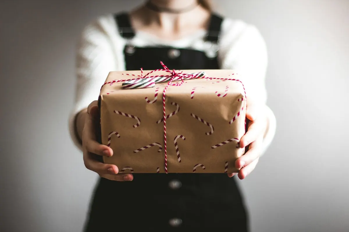 Hands holding a wrapped gift for a white elephant exchange